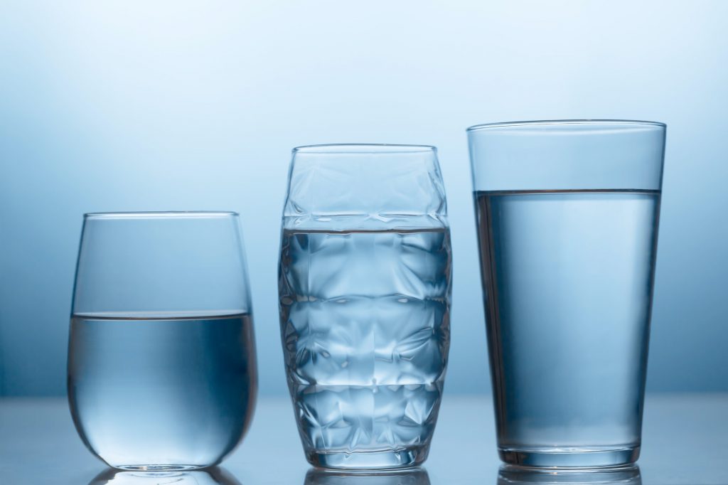 Fresh water in a three glasses on the blue background